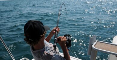 Pescador pescando con caña desde embarcación